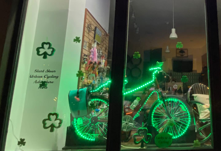 Bike with green lights and shamrocks in Earth Rider bike shop window with theme lucky to be cycling
