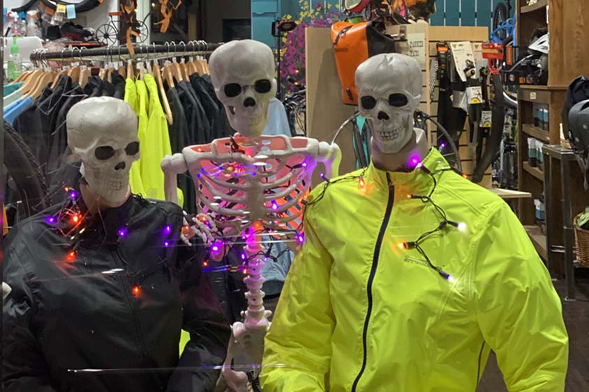 Skeletons in Earth Rider bike shop window wearing waterproof bike jackets in reflective black and hi visibility yellow