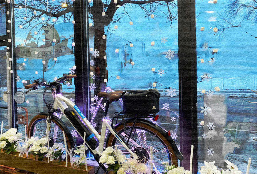 Ebike in window display with winter scene of snow, snowflakes, and flowers