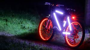 Bicycle at night with lights on wheels frame and a rear light