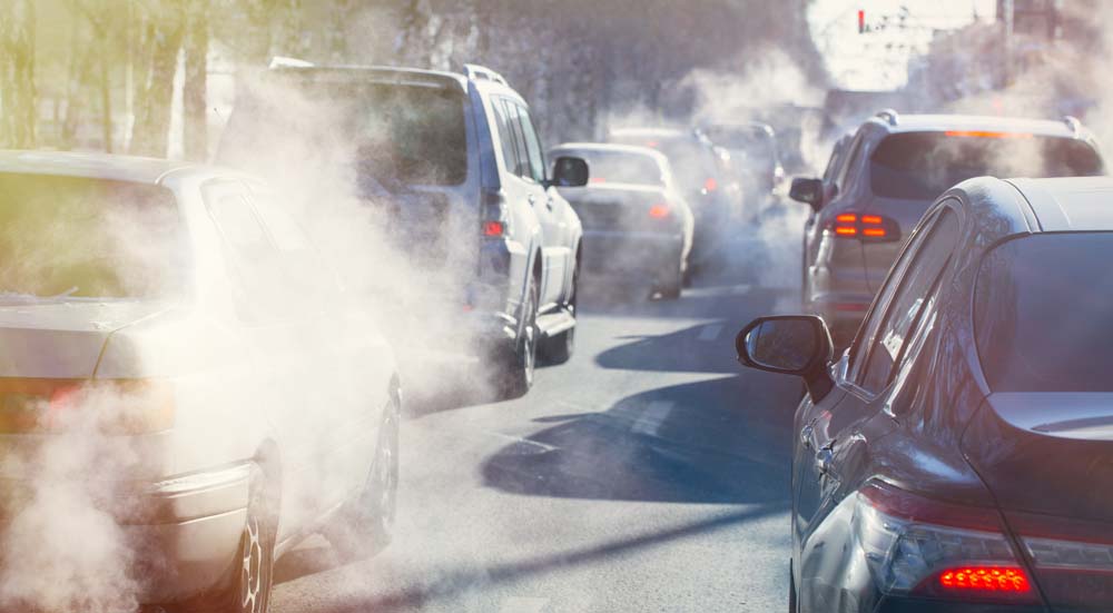 Cars sitting in traffic spewing pollution