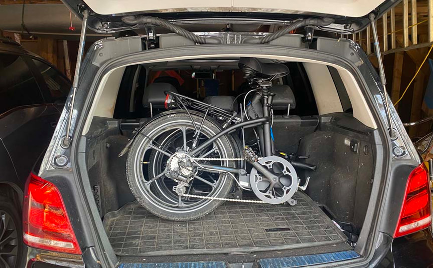 Magnum brand folding ebike in hatchback trunk of SUV car
