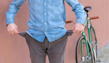 Man standing in front of a bike with empty pockets