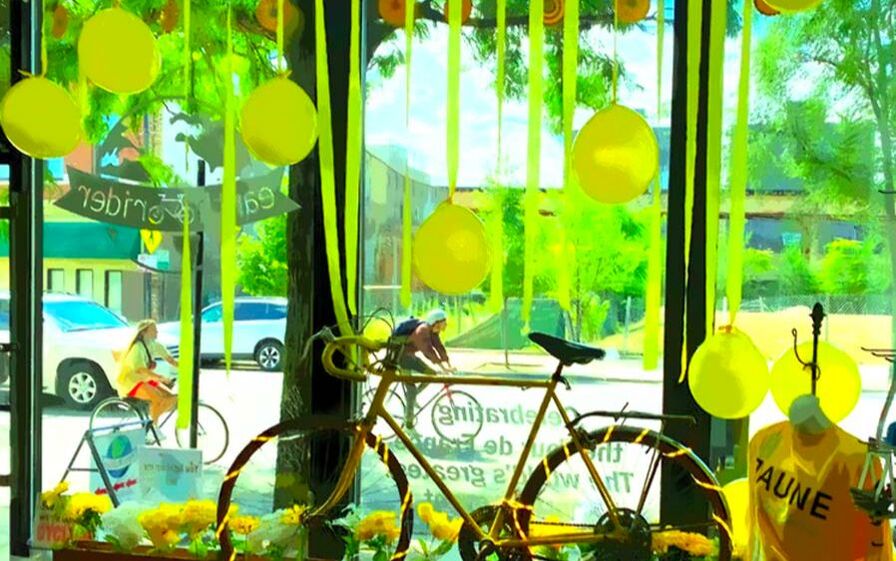 Bike shop window with yellow bike, streamers and balloons