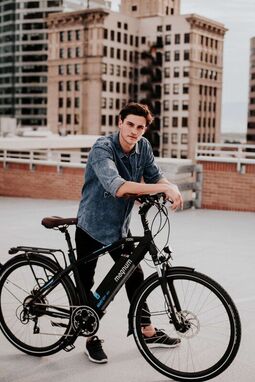 Man standing next to an ebike in an urban setting