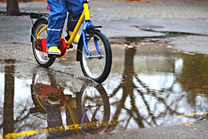 Riding a bicycle through a pedal wearing water proof pants