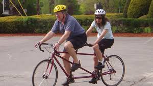 Couple riding a tandem bicycle built for two